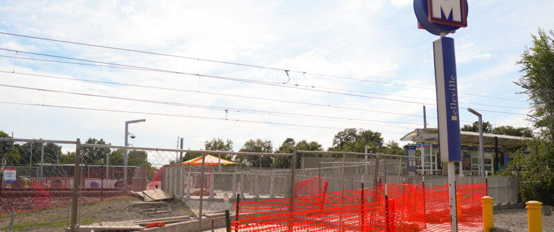 Construction fencing underneath a MetroLink station sign.